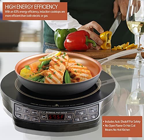 Induction cooktop with grilled fish dish and chopped vegetables