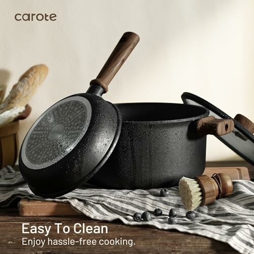 Nonstick cookware set with wooden handles on a kitchen counter.