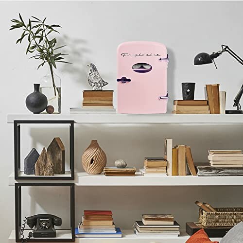 Pink mini fridge on a decorative shelf with books and vases