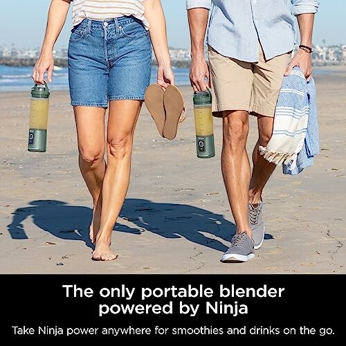 Two people walking on a beach holding portable blenders.