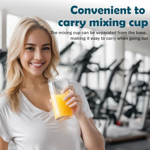 Woman holding a mixing cup with orange juice in a gym setting.